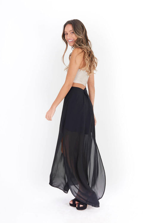 Arriendo de Crop top dorado cuello halter y pollera negra con transparencia