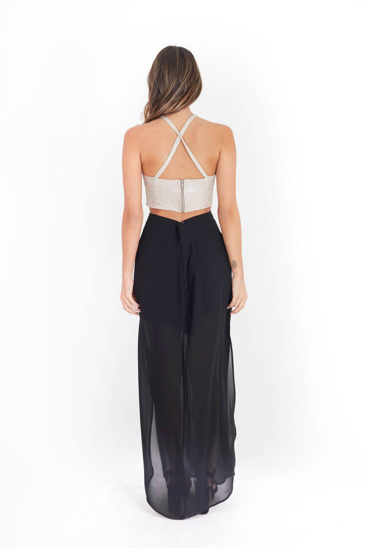 Arriendo de Crop top dorado cuello halter y pollera negra con transparencia